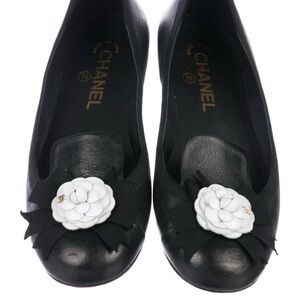 Black Chanel ballet flats with round toes, Camellia accents at vamps.